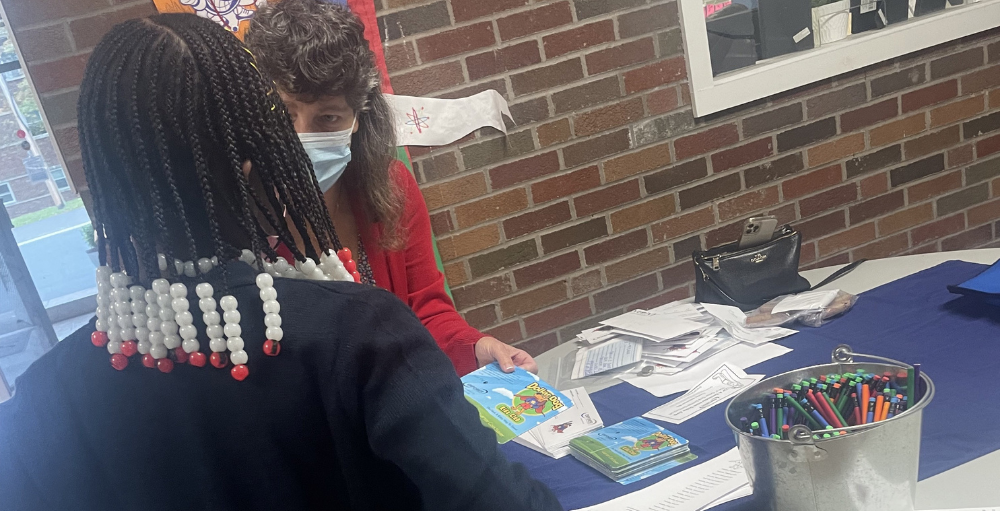 Syracuse Academy of Science and Citizenship elementary school students deposit money into their savings account through Empower Federal Credit Union’s Dollar Dog program.