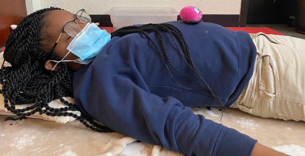 Syracuse Academy of Science and Citizenship elementary school student demonstrates how to do a belly breathing exercise.
